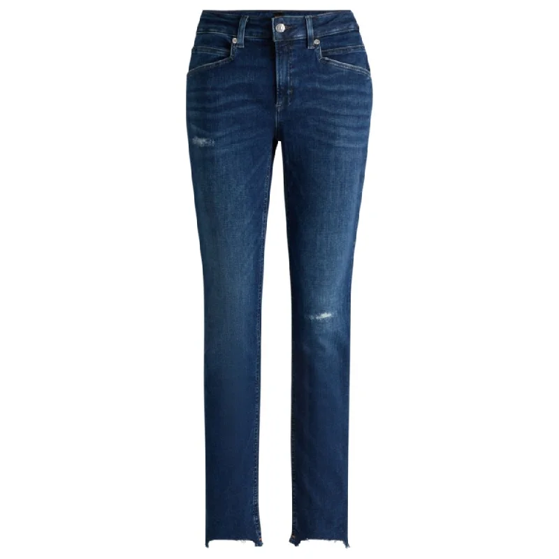 Blue jeans in distressed stretch denim with frayed hems